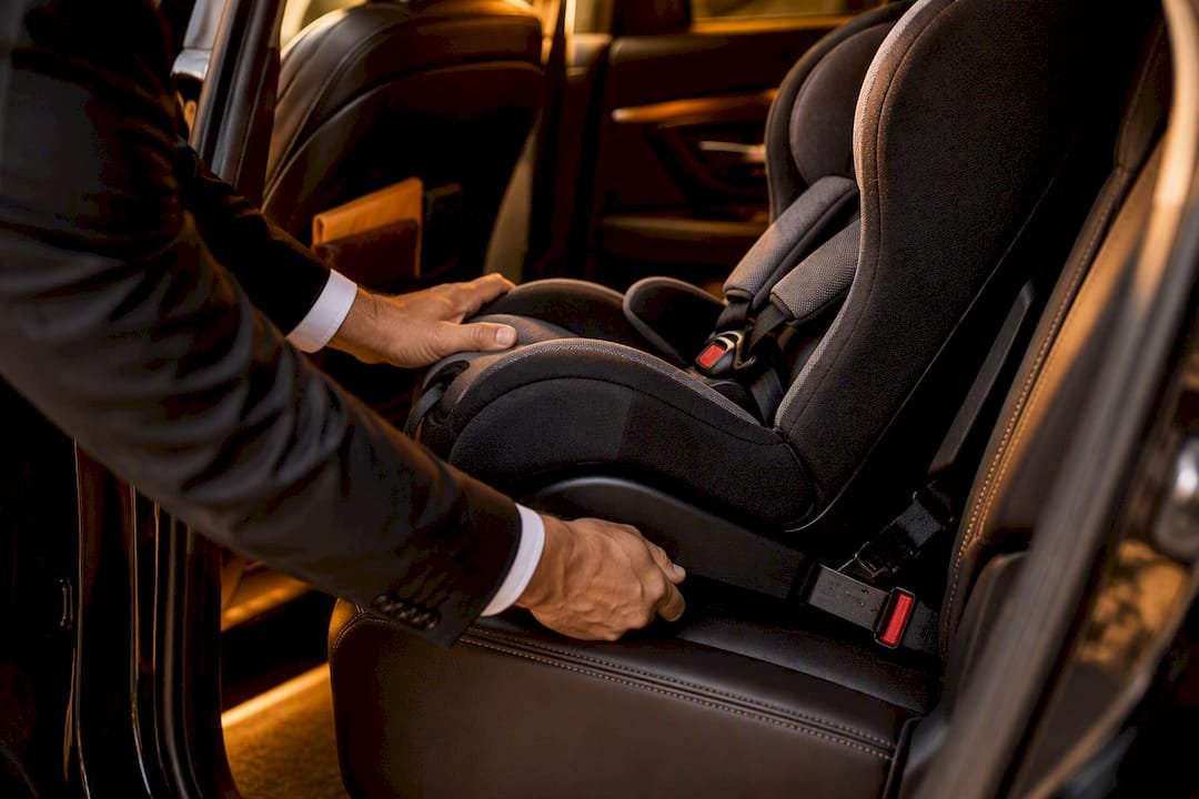 Hands checking an installed child restraint