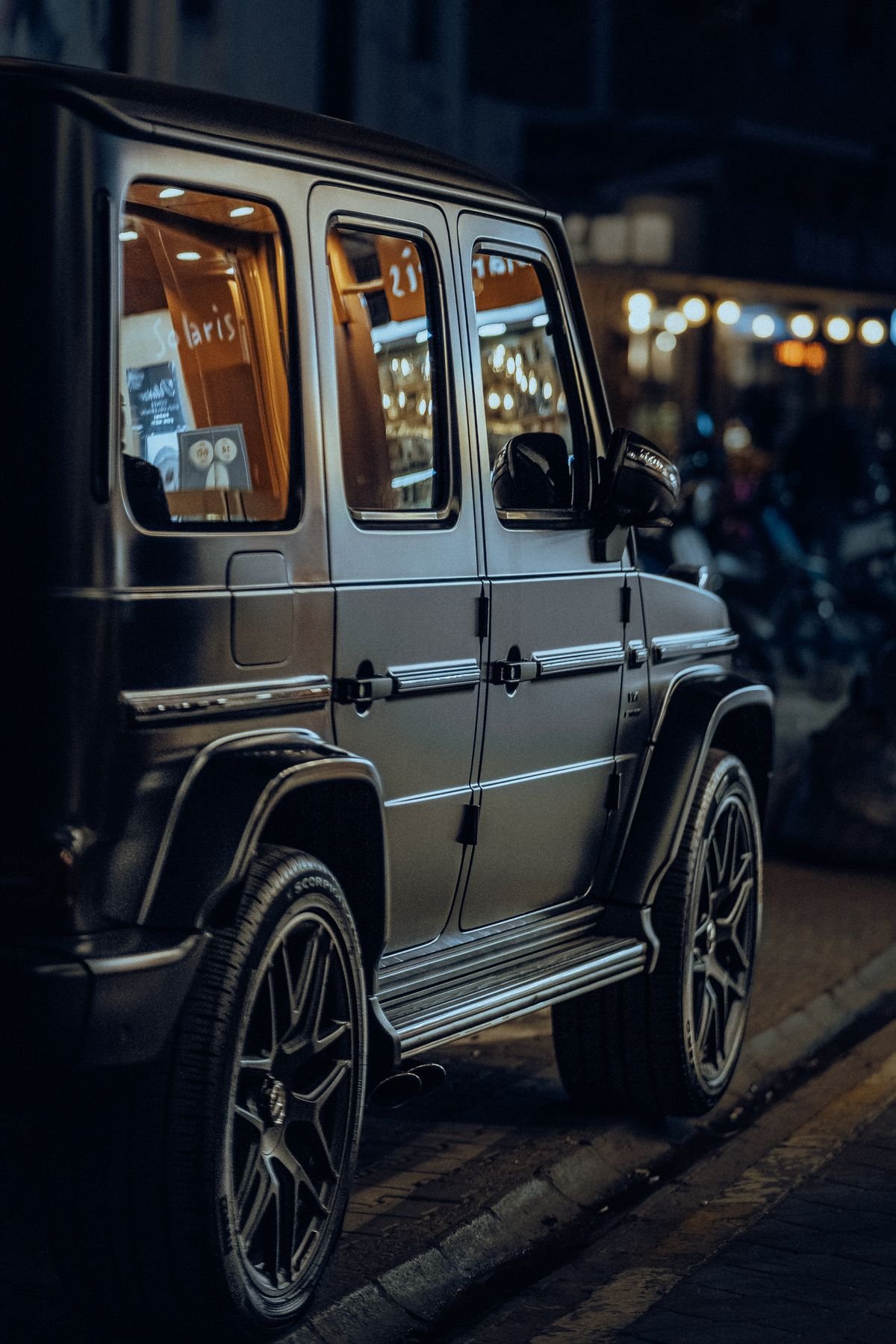 Black luxury SUV waiting outside an LA bar at night for night-out car service
