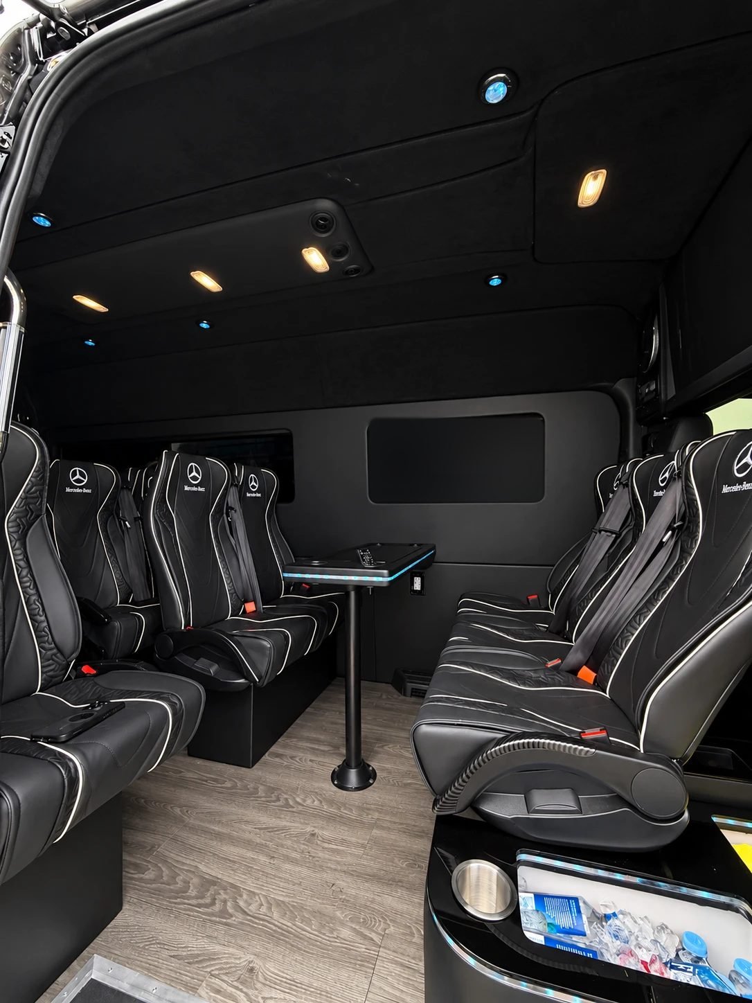 Comfort Executive Sprinter, Los Angeles — Mercedes-Benz leather seats facing a centre table, with a lit drinks cooler at the door