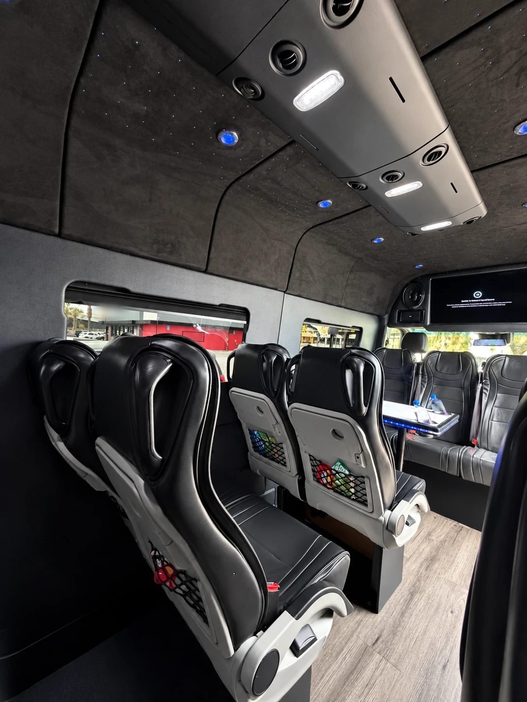 Comfort Executive Sprinter, Los Angeles — forward-facing seats with seat-back pockets under a starlight ceiling and front screen